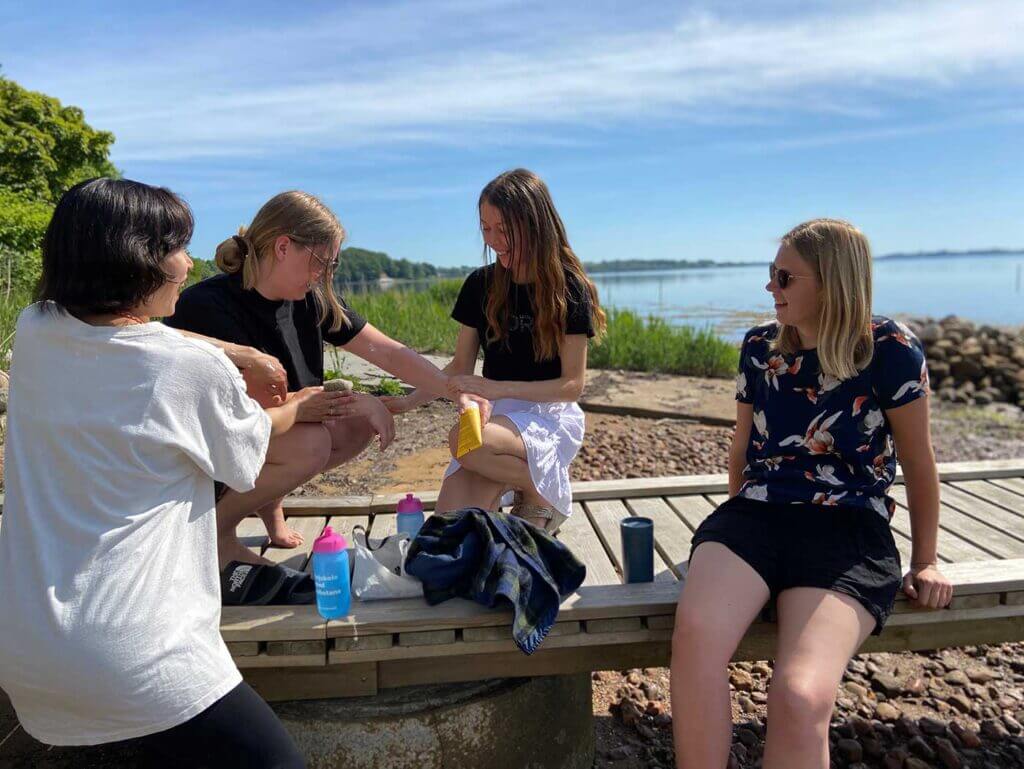 Lange højskoleelever sidder på Rønshoved Højskoles badebro